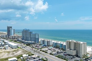 Eine Küstenstadt mit hoch aufragenden Hotels, einem Strand und blauem Himmel.