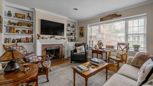 A living room with a fireplace, bookshelves, a television, and comfortable seating. - Cute bungalow located in the Fairwood  neighborhood of Lexington. #15081244-1 (Lexington)
