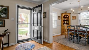 A dining area with a table, chairs, a chandelier, and a view through an open door. - Cute bungalow located in the Fairwood  neighborhood of Lexington. #15081244-1 (Lexington)