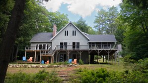 A two-story house with a balcony, a deck, and a chimney.