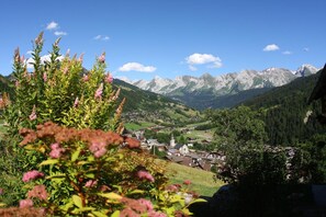 Un village de montagne à l’architecture traditionnelle, avec une église et une vue sur la vallée.