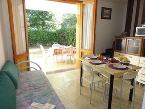 Enjoy a functional room with a kitchenette, dining area, and sliding glass door leading to an outdoor space.