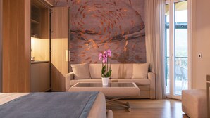 A modern hotel room with a sofa, a coffee table, and a bed. - Miramare Suites (Sestri Levante)