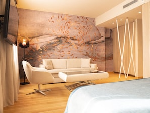 Habitación Deluxe | Área de sala de estar | Smart TV de 50 pulgadas con canales digitales y televisión 