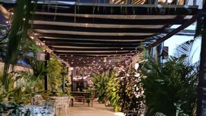 An outdoor patio area with a pergola, string lights, and potted plants. - Casa Ines Hostal a place especially for you... (Santa Marta)