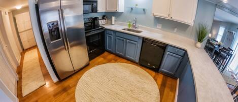 A modern kitchen with a stainless steel refrigerator, a microwave, and a dishwasher.
