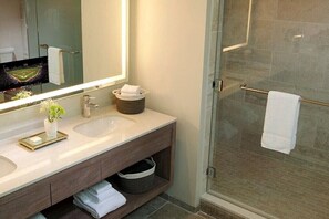 Enjoy a refreshing shower in this bathroom with a glass-enclosed shower, sink, and large mirror.