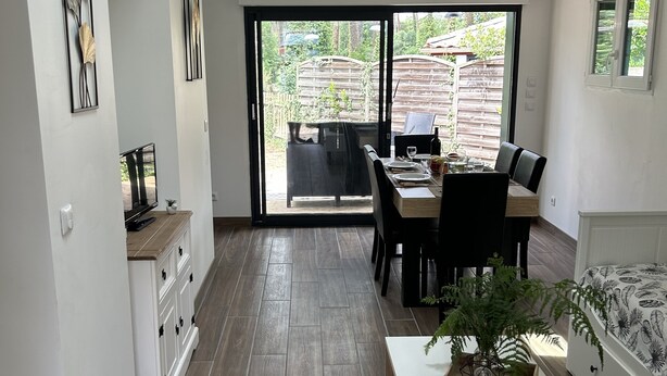 Et moderne køkken med spiseplads, store vinduer og en skydedør til en patio.