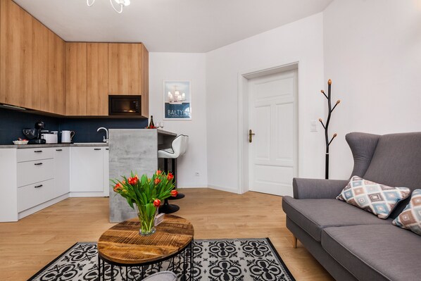 Un salon moderne avec un canapé gris, une table basse en bois et un vase de tulipes.