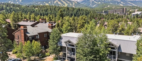 A residential area with modern houses, a parking lot, and a mountain backdrop.