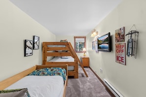 A bedroom with bunk beds, a TV, and various wall decorations. - Cozy Breckenridge Condo Near Peak 9 & Main Street (Breckenridge)