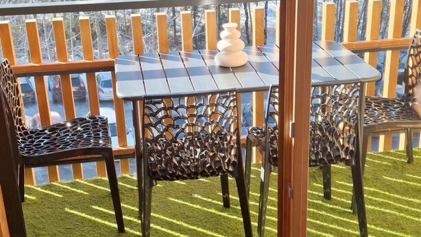 A balcony with a table and chairs, a view of a snowy landscape, and a wooden railing. - 3rd floor, view mountain, balcony, tv, ski locker, 36m², Le Grand Bornand (Le Grand-Bornand)