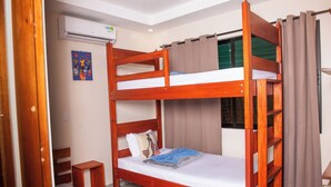 A bunk bed room with a window, a small bedside table, and a wall-mounted air conditioner. - VillasLunaAfricana–101 (Puerto Viejo de Talamanca)
