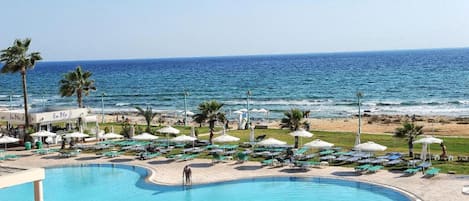 Piscine extérieure, parasols de plage, chaises longues