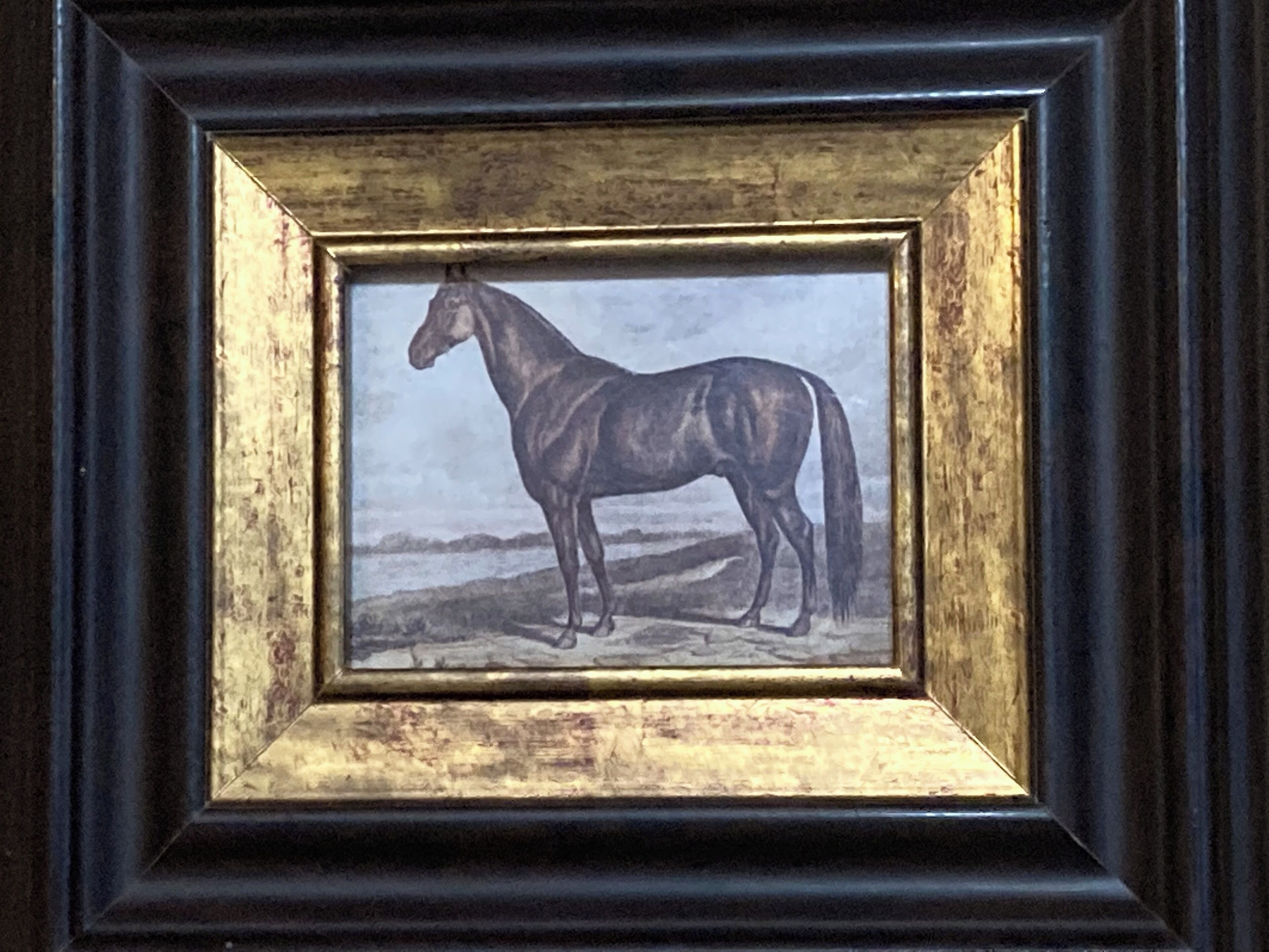 A framed painting of a horse.