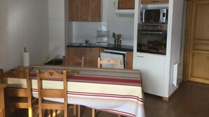 A compact kitchen with wooden cabinets, a microwave, and a dishwasher.