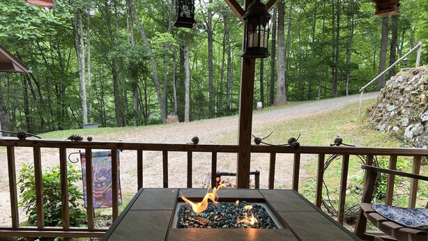 A fire pit table with a view of a forested area. - Rose Creek Retreat (Franklin)