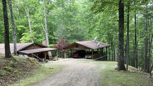 A cabin with a gravel driveway leading to a covered parking area. - Rose Creek Retreat (Franklin)