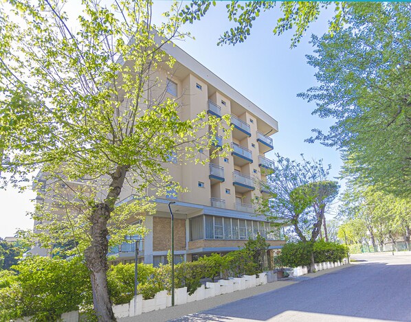 A multi-story hotel with balconies, surrounded by trees and a paved road. - Hotel Ben Hur Beach & Breakfast (Cesenatico)