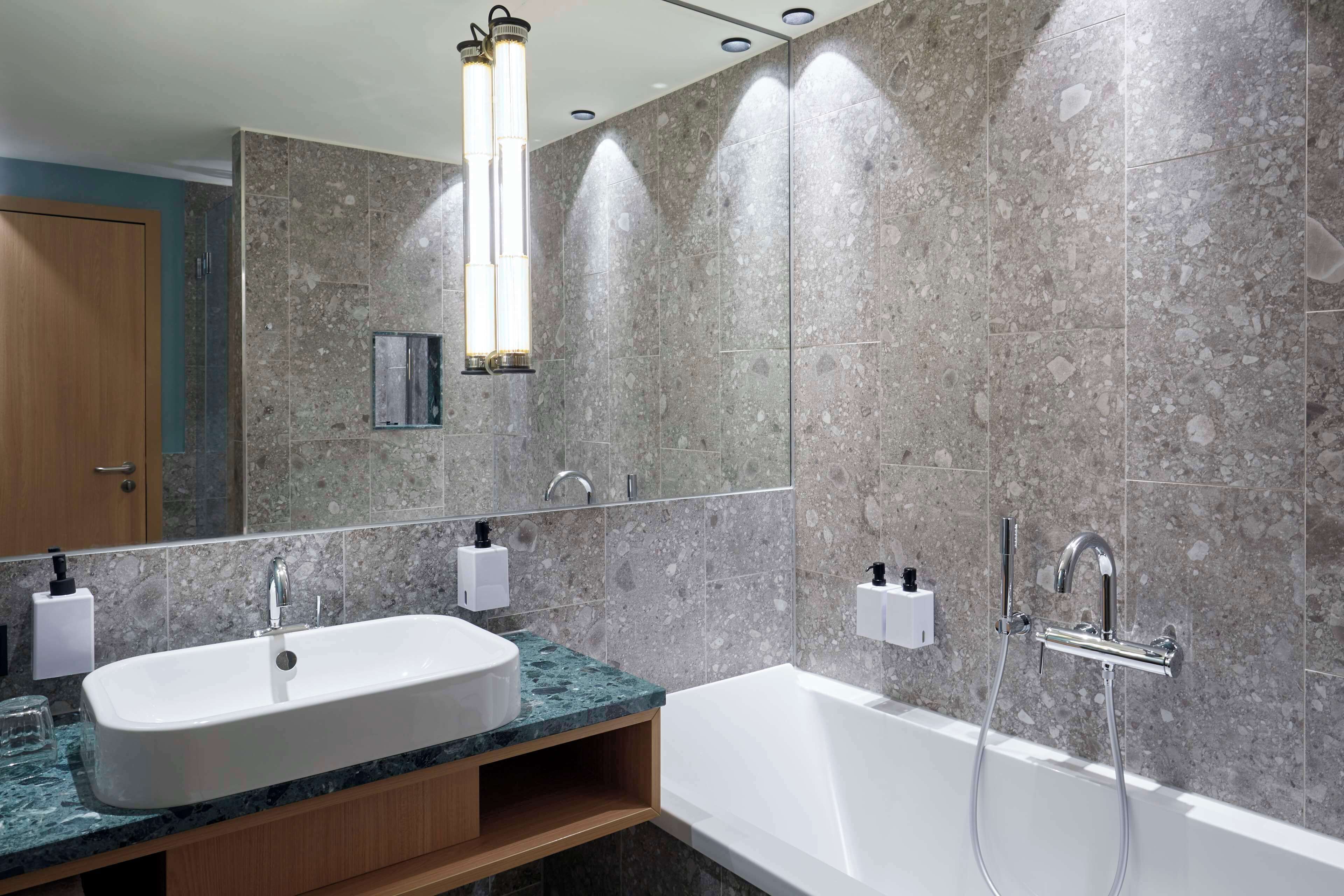 Une salle de bain moderne avec un double vasque, une baignoire et un grand miroir.