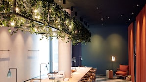 A conference room with a long table, chairs, and a hanging plant installation.