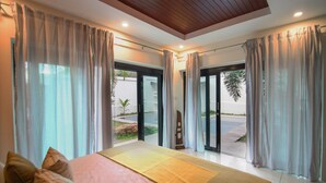 A bedroom with a large bed, curtains, and a view of the outside. - Resona Pool Villa by Aonanta Group (Krabi)