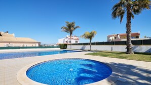 A swimming pool with a tiled border, surrounded by a tiled deck. - Apartment Diana with pool (Albufeira)