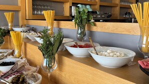 En buffé med ett varierat utbud av mat och ett vinställ i bakgrunden.