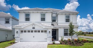 Stunning two-story home with a garage, porch, and beautifully manicured lawn.