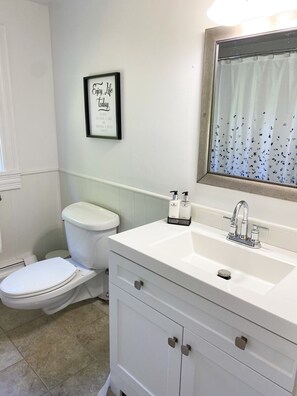 Une salle de bain avec des toilettes, un lavabo et une citation inspirante encadrée au mur.