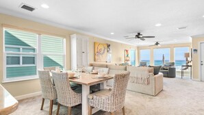 A spacious living room with a dining area, large windows, and a view of the ocean. - On the Beach, Big Deck, Chair Service, Steps onto the Sand (Miramar Beach)