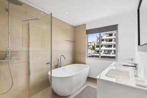 Bathtub, hair dryer, towels, toilet paper