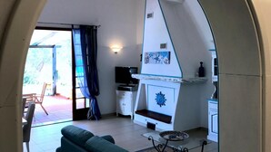 A cozy living room with a sofa, a TV, and a fireplace. - Villa La Maddalena in La Maddalena (La Maddalena)