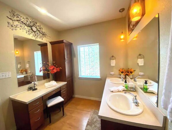Une salle de bain moderne avec deux lavabos, un grand miroir et un élément décoratif mural.