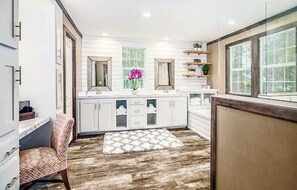 Kitchen features a central island, windows, and a mirror above, perfect for meal preparation and relaxation.