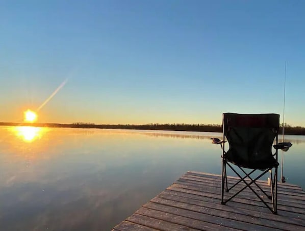 Relax on the lakeside dock with a single chair, perfect for contemplation.
