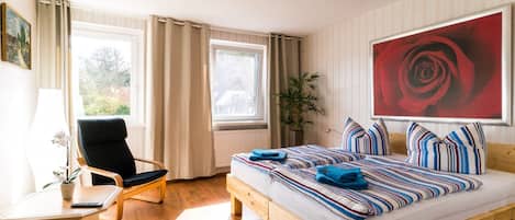 Una camera da letto con un letto di legno, una scrivania, una sedia e un'ampia finestra.