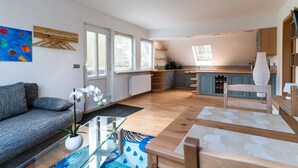 A modern apartment with a living room, kitchen, and dining area. - Landhotel Prälank (Neustrelitz)