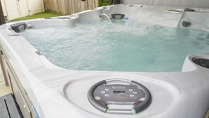 A hot tub with a control panel and water jets.