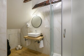 Een douche, een haardroger, handdoeken, toiletpapier