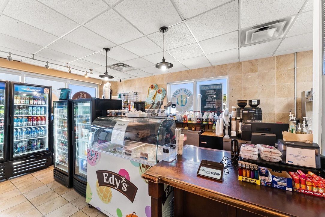 A bakery counter with a display case, refrigerated beverage coolers, and a variety of bakery items.