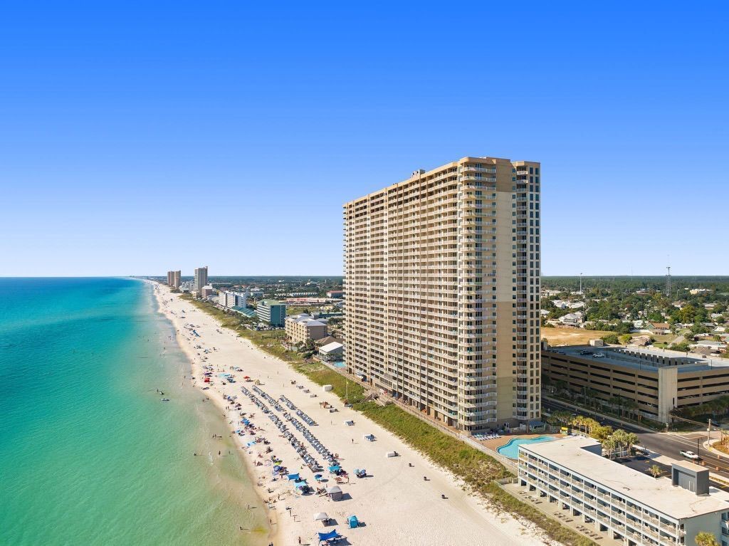 Ein Hochhaus-Hotel mit Blick auf den Strand, einem Pool und einer Tiefgarage.