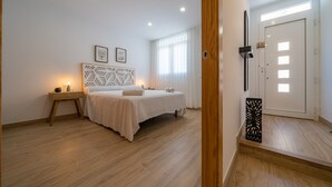 A bedroom with a bed, bedside table, and a door with a light switch. - HomeHolidaysRentals Benoit - Costa Barcelona (Pineda de Mar)
