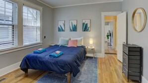 Un dormitorio con cama, mesita de noche, cómoda y ventilador de techo.