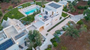 Ein modernes Haus mit Swimmingpool, Solaranlage und einem gepflegten Garten.