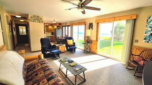 A living room with a sofa, armchairs, a coffee table, and a view of the outdoors.