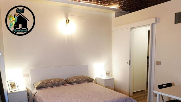 Una camera da letto con un letto, due comodini, una sedia e una porta.