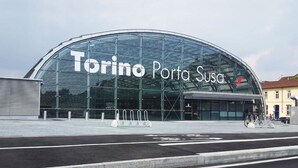 Un edificio moderno in vetro con la scritta "Torino Porta Susa" sulla facciata.