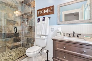 A bathroom with a shower, toilet, vanity, and a 'HOME' sign. - Hilltop Haven w/ Hot Tub, Mountain Views & Game Room (Black Mountain)