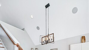 Eine moderne Küche mit einer Holztreppe, Edelstahlgeräten und weißen Schränken.